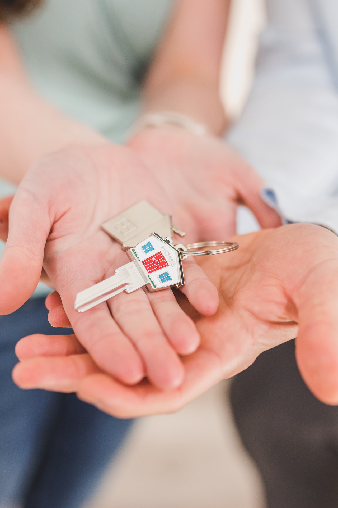 person holding keys shaped like a home